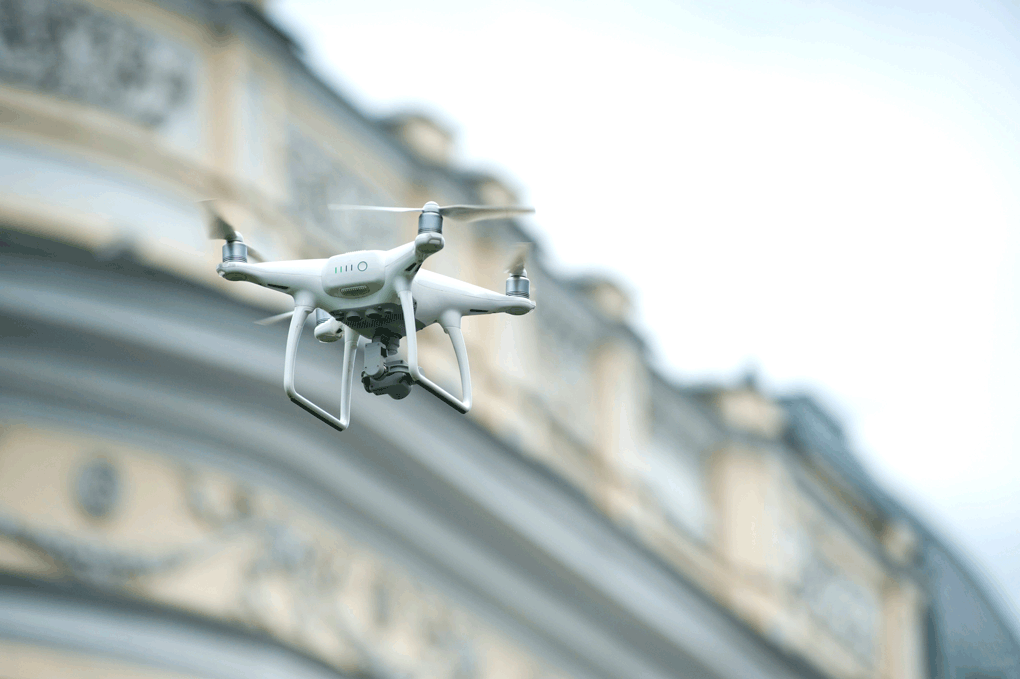 drone_building drone flying in front of a building